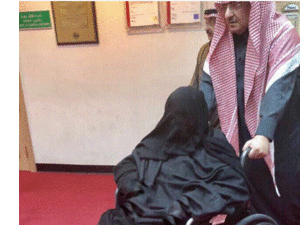 ابن نايف يدفع كرسيا متحركا تجلس عليه والدته، وذلك أثناء خروجهما من المشفى