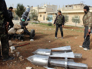 Opposition fighters load a homemade rocket launcher during clashes with government forces in the town of Khan Sheikhun, in Syria's Idlib province. (AFP/File)