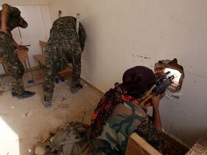 Members of the Kurdish People's Protection Units (YPG) take position in a classroom in the village of Maarouf in the northeastern Syrian province of Hasakah on July 16, 2015. (AFP/Youssef Karwashan)