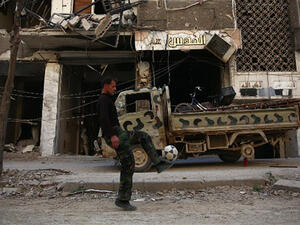 A rebel fighter plays football in a damaged street in the neighbourhood of Jobar, on the eastern outskirts of the Syrian capital Damascus. (AFP/File) 