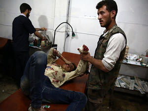 A wounded Syrian boy awaits treatment by doctors at a makeshift hospital in the rebel-held area of Douma, east of the capital Damascus, following reported air strikes on the city on May 11, 2015. (AFP/Abd Doumany)