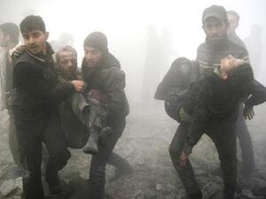 Syrian men carry injured victims following a reported airstrike on the besieged rebel-held town of Douma on Jan. 21, 2015. (AFP/Sameer al-Doumy) 