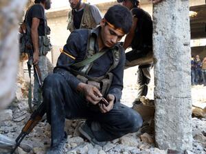 A rebel fighter reloads the magazine of his weapon during clasahes with regime forces in Ramussa on the southwestern edges of Syria's northern city of Aleppo on August 6, 2016. (AFP/Hadi Al-Falabi)