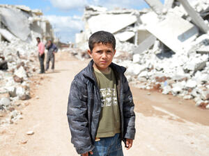 A young Syrian boy poses for a picture between destroyed houses in the northern Syrian town. (AFP/File)