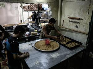 Syrians preparing traditional sweets for Ramadan in a bakery on June 28, 2016. (AFP/Sameer Al-Doumy)