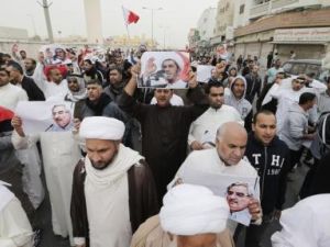محتجون يحملون صورا للشيخ علي سلمان زعيم جمعية الوفاق أثناء مظاهرة في المنامة

