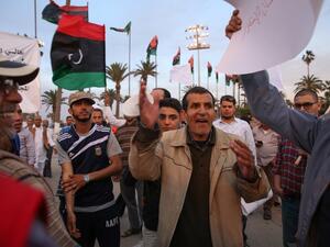 Supporters of Libya's new prime minister-designate Fayez al-Sarraj protest holding banners and their national flag in support of the new government in Tripoli's Martyr's Square on March 31, 2016. (AFP/Taha Jawaishi)