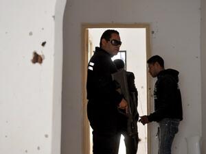Tunisian gendarmes walk inside a house where two suspected jihadists were killed during a security operation on May 11, 2016 in the town of Mnihla, in Ariana province just outside Tunis. (AFP/Fethi Belaid)