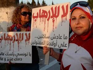 Women hold signs reading "no to terrorism" outside the National Bardo Museum in Tunis, which was attacked by Daesh-affiliated gunmen in March.  (AFP/Fadel Senna)