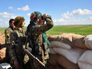 Members of the Kurdish People's Protection Units monitor the positions of Islamic State group in the Syrian town of Ras al-Ain, close to the Turkish border. (AFP/File)