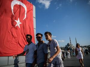 Young people walk on Galata bridge next to a giant Turkish national flag at Eminonu district in Istanbul on July 26, 2016. (Ozan Kose/ AFP) Young people walk on Galata bridge next to a giant Turkish national flag at Eminonu district in Istanbul on July 26, 2016. (Ozan Kose/ AFP)