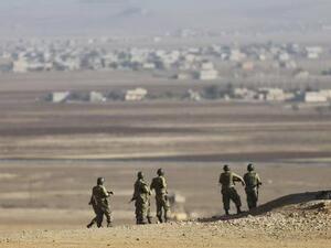 جنود اتراك يتابعون المعارك الدائرة في كوباني على الجانب المقابل من الحدود في سوريا