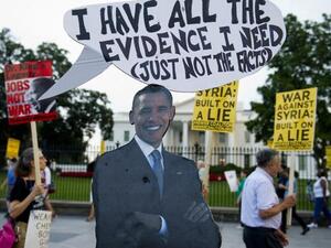  A cutout of US President Barack Obama stands on the sidewalk as demonstrators march in protest during a rally against a possible US and allies attack on Syria in response to possible use of chemical weapons by the Assad government, in Lafayette Park in front of the White House in Washington, DC on August 29, 2013. AFP PHOTO / Saul LOEB