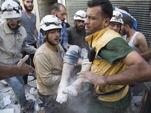 White Helmets rescue a child after a strike in Syria (AFP/FILE)