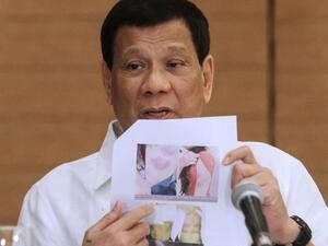 Philippine President Rodrigo Duterte shows a photo of a Filipina worker in Kuwait, who he said had been abused by her employer (AFP/File Photo)