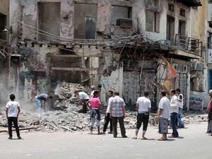 Yemeni people inspect the damage to a building in Aden. Image used for illustrative purposes. (Al Bawaba/File)