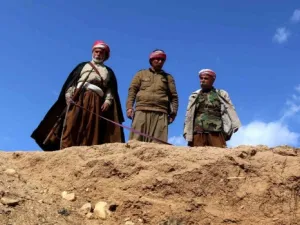 Yazidis look down on a mass grave. (AFP/File)