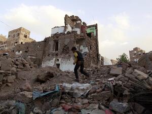 A file photo of a Yemeni boy walking through the rubble of a Saudi-led airstrike on Sanaa. (AFP/Mohammed Huwais)