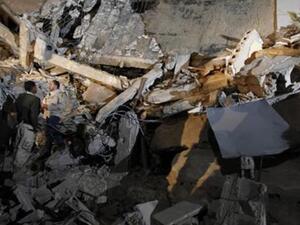 جنود من كتائب القذافي يقفون وسط الحطام بعد غارة لقوات التحالف داخل باب العزيزية في طرابلس