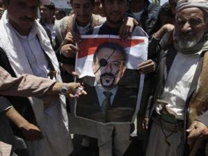محتجون مناهضون للحكومة يحملون صورة ساخرة للرئيس اليمني علي عبد الله صالح في صنعاء