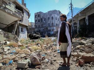 A Yemeni man inspects the damage on a street following clashes between pro-government militants and Shia Houthi rebels on November 22, 2016 in the country's third-city Taiz. (AFP/Ahmad al-Basha)