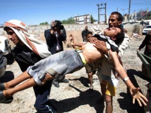 أشخاص يسعفون جريحا أصيب خلال المواجهات بين المتظاهرين والأمن في صنعاء 