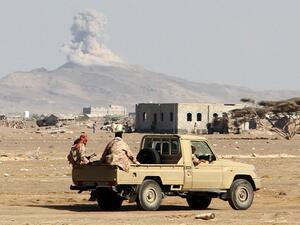Smoke billows in the distance as Yemeni pro-government forces patrol during clashes with Houthi rebels in Yemen's western Dhubab district, on January 9, 2017. (AFP/Saleh al-Obeidi)