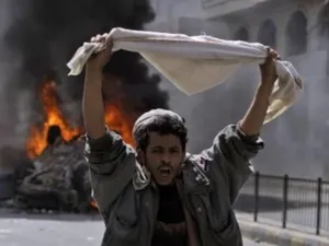 متظاهر يقف امام مركبة محترقة في صنعاء