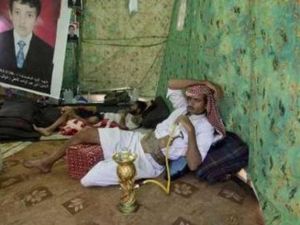 يمني يدخن الارجيلة داخل خيمة في ساحة الاعتصام في صنعاء