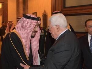 ارشيفية/ الرئيس الفلسطيني محمود عباس (يمين) مصافحا العاهل السعودي الملك سلمان بن عبد العزيز