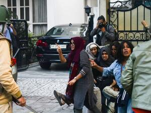 لقطة من الفيديو تظهر عائشة وهي تقارع رجال الشرطة بينما تحمي الشاب من هراواتهم