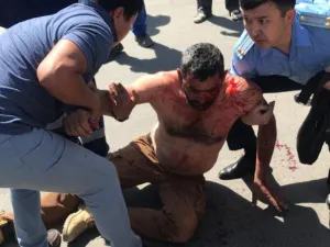 احد المهندسين الذين جرى الاعتداء ع ليهم  والدماء تغطيه في حين تحاول الشرطة حمايته
