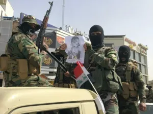 عناصر من مليشيا "ربع الله" يحملون صورة رئيس الحكومة العراقية مصطفى الكاظمي وعليها طبع حذاء