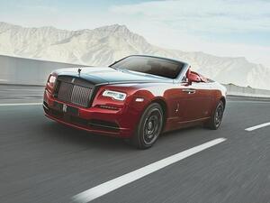 كانت السيارة الحمراء المكشوفة بخطوطها الكلاسيكية في تناقض حاد مع المناظر الطبيعية الصخرية 