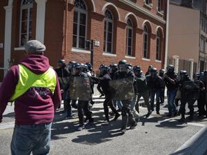 Police officers run in lines as they face a "Yellow vest" (Gilets Jaunes) protester  (AFP)