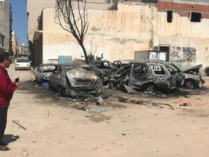 A Libyan man looks at damaged vehicles at the scene of an overnight rocket attack which no group claimed responsibility for so far in the Libyan capital Tripoli (AFP)