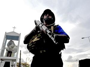 A Sri Lankan soldier stands guard near a car explosion after the police tried to defuse a bomb near St. Anthony's Shrine in Colombo  (AFP)
