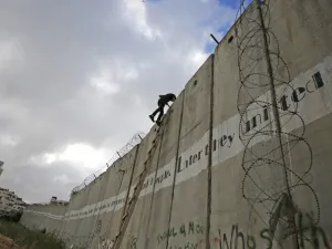 Palestinian youths climb a section of Israel's separation wall to reach at the al-Aqsa Mosque compound in Jerusalem (AFP)