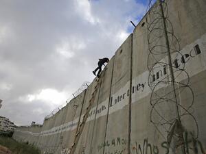 Palestinian youths climb a section of Israel's separation wall to reach at the al-Aqsa Mosque compound in Jerusalem (AFP)