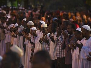 Supporters of Sudanese Islamist movements perform the Maghrib (sunset) prayer ahead of Iftar (AFP)
