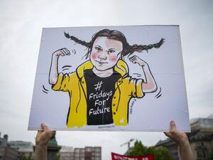 A protester holds up placard depicting the 16-year-old Swedish climate activist Greta Thunberg  (AFP)