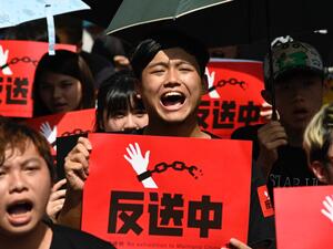 Protesters display placards during a demonstration in Taipei  (AFP)