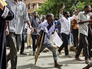 A Sudanese protester walking with a crutch joins others in a march during a mass demonstration against the country's ruling generals in the capital Khartoum's twin city of Omdurman on June 30, 2019.  Ahmed MUSTAFA / AFP