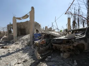 The ruins of a building and the wreckage of a vehicle lie  (AFP)