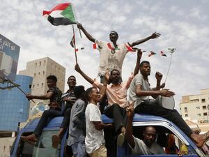 Sudanese people celebrate in the streets of Khartoum after ruling generals and protest leaders announced they have reached an agreement on the disputed issue of a new governing body  (AFP)