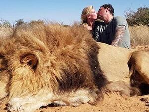 Disgusting parasites Darren and Carolyn Carter from Edmonton, Alberta, killed at least two lions and pose for kissing photo in front of dead lion (Twitter)