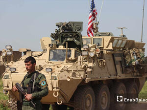 مسلح من الوحدات الكردية بجوار مدرعة أمريكية