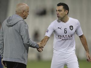 Sadd's coach Jesualdo Ferreira speaks with midfielder Xavi 