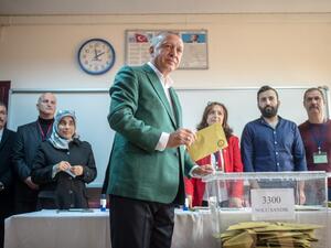 In this file photo taken on March 31, 2019 Turkish President Tayyip Erdogan (C) stands prior to cast his ballot at a polling station during the municipal elections in Istanbul. (BULENT KILIC / AFP)