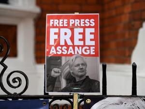 A supporter of WikiLeaks founder Julian Assange holds a placard outside the Ecuadorian Embassy in London on April 5, 2019, following rumours that Assange was about to be expelled. (Daniel LEAL-OLIVAS / AFP)